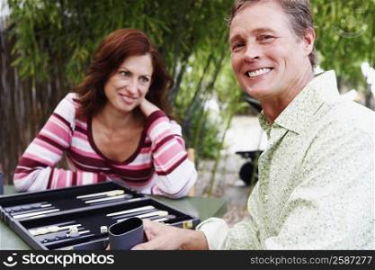 Mature man and mature woman playing backgammon