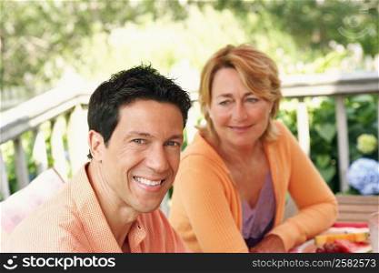 Mature man and mature woman sitting at the table and smiling