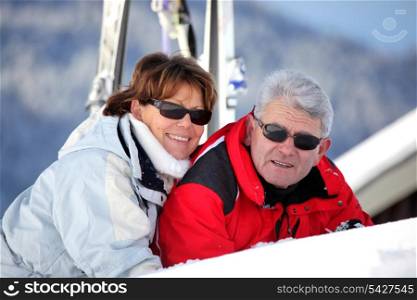 Mature man and woman smiling laid in snow