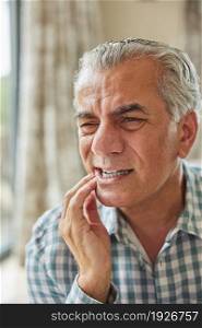 Mature Man At Home Suffering From Pain With Toothache