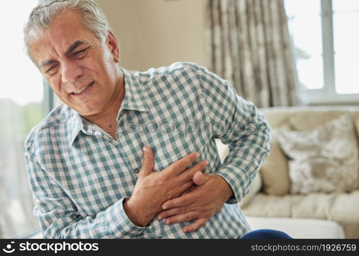 Mature Man Clutching Chest And Suffering Heart Attack At Home