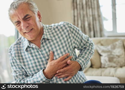 Mature Man Clutching Chest And Suffering Heart Attack At Home