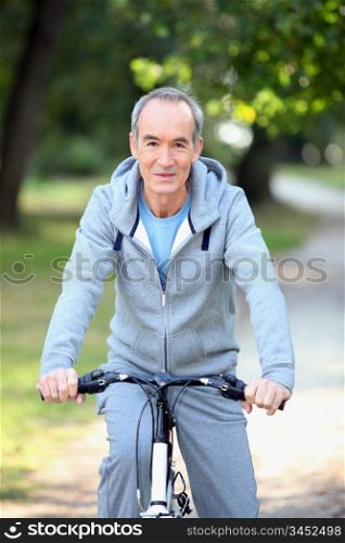 mature man doing bike in the forest