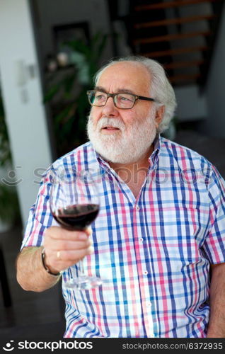 Mature man drinking wine at home