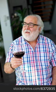 Mature man drinking wine at home