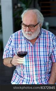 Mature man drinking wine at home