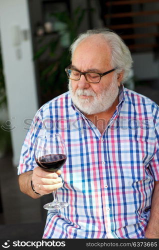 Mature man drinking wine at home