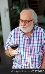 Mature man drinking wine at home
