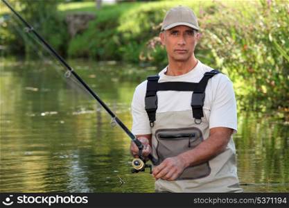 Mature man fishing in a river