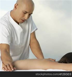 Mature man giving a young woman a back massage