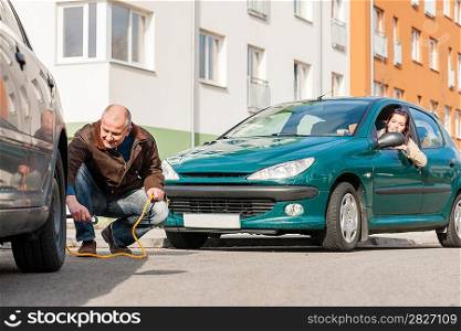 Mature man helping woman with her car breakdown broken problem