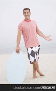 Mature man holding a body board on the beach