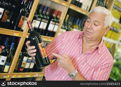 Mature man holding a bottle of wine