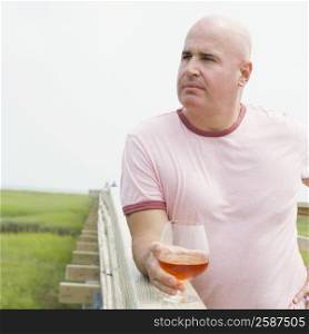 Mature man holding a glass of wine and looking away