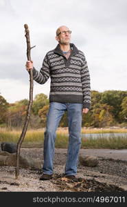 Mature man holding a stick