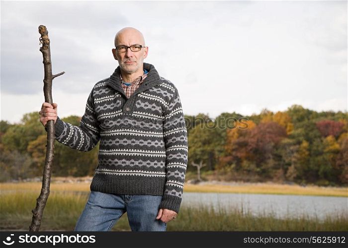 Mature man holding a stick