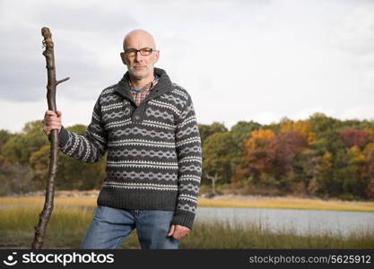 Mature man holding a stick