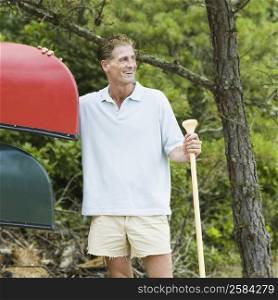 Mature man holding an oar and smiling