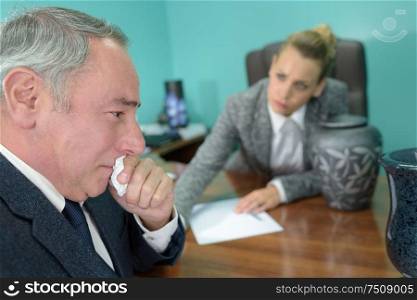 mature man in tears during meeting with funeral director