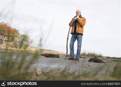 Mature man leaning on a stick