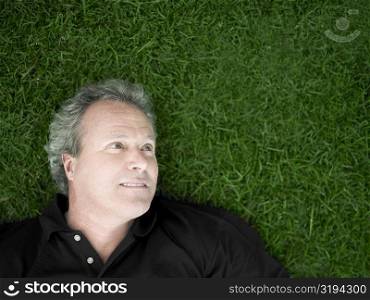Mature man lying on the grass in a park