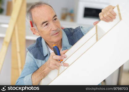 mature man measuring wooden shelf