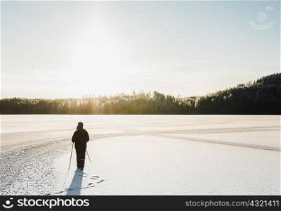 Mature man nordic walking through snow covered field