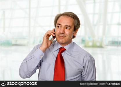 mature man on the phone at the office