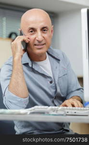 mature man on the phone in his office