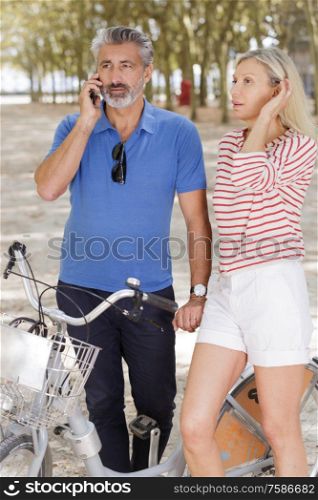 mature man on the phone with wife in the park