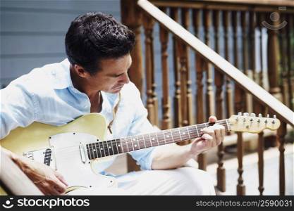 Mature man playing the guitar