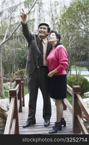 Mature man pointing to a mature woman smiling