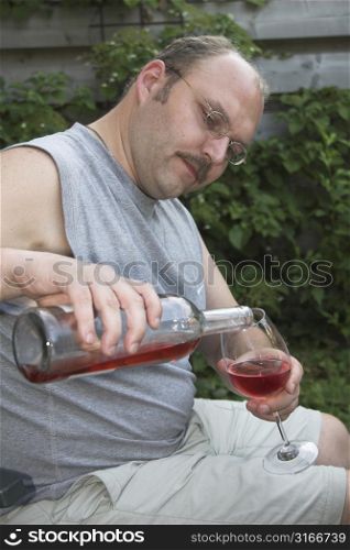 Mature man pouring a glass of wine