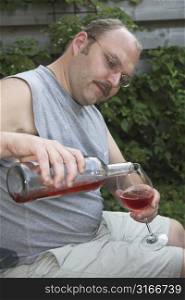 Mature man pouring a glass of wine