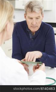 Mature Man Reading Leaflet In Doctor&rsquo;s Surgery