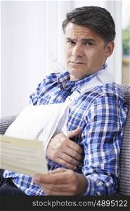 Mature Man Reading Letter About Injury