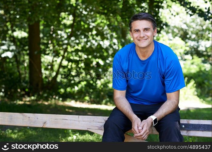 Mature Man Resting Whilst Exercising In Countryside