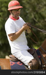 Mature man riding a horse