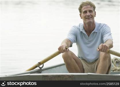 Mature man rowing a boat