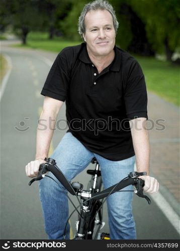 Mature man sitting on a bicycle and smiling