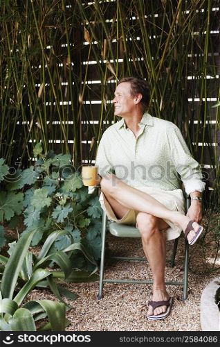 Mature man sitting on a chair and holding a mug