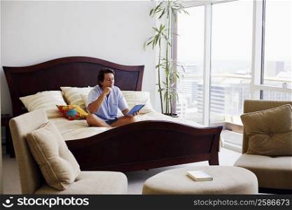 Mature man sitting on the bed reading a book