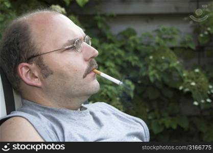 Mature man smoking a cigarette while contemplating his day