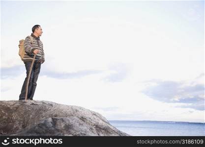 Mature man standing on a rock at the seaside