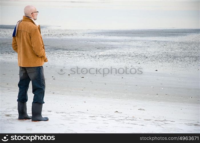 Mature man standing on an empty beach