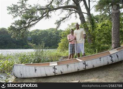 Mature man standing with a mid adult woman at a lakeside and smiling