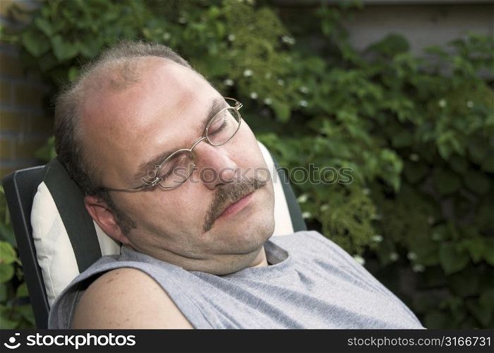 Mature man taking a nap in the garden
