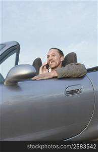 Mature man talking on a mobile phone in a car