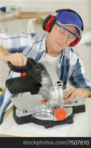 mature man using circular saw