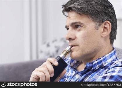 Mature Man Using Vapourizer As Smoking Alternative